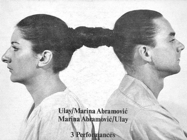 Photographie en noir et blanc, une femme et un homme de dos, leur cheveux sont noués ensemble