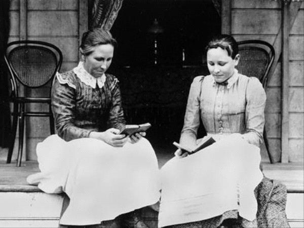 Deux femmes lisent assises sur une véranda,  vieille photographie en noir et blanc